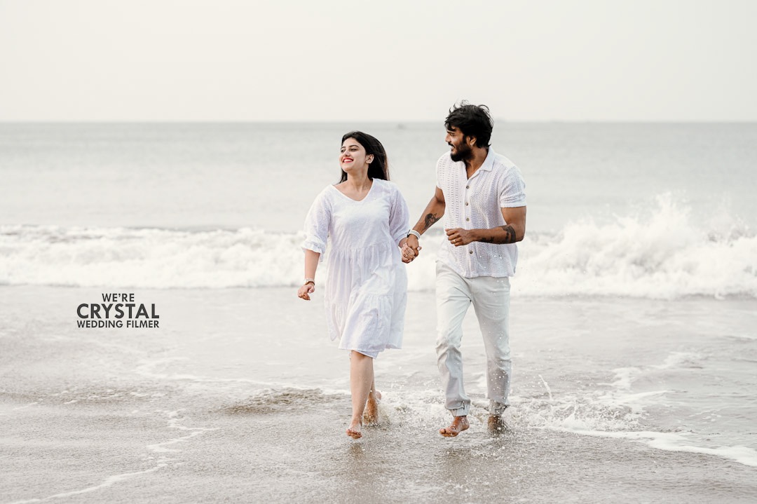 Couple walking hand-in-hand on a Kerala beach for their save the date.