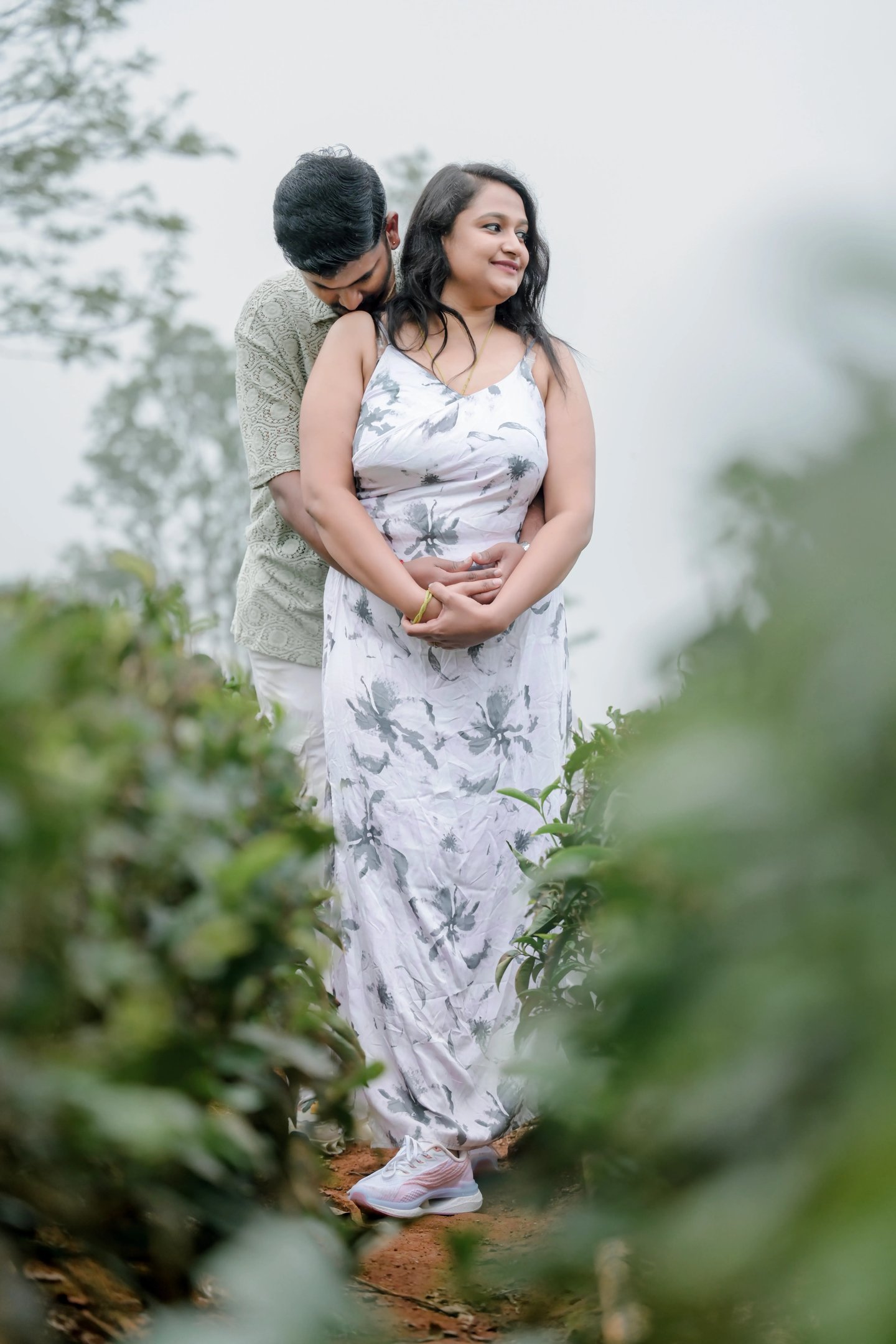 A playful moment as the couple runs through the Ooty rain with an umbrella.