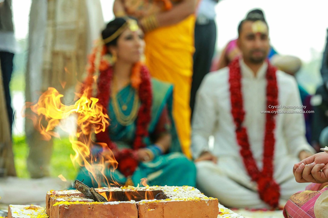 destination wedding photography in kerala bride and groom sitting infron tof holy fire